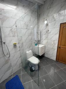 uma casa de banho com um WC e uma cabina de duche em vidro. em San Marcos Envigado Medellin em Envigado