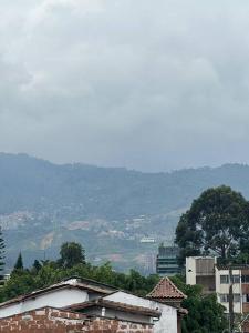 un edificio de ladrillo en una ciudad con montañas en el fondo en San Marcos Envigado Medellin en Envigado