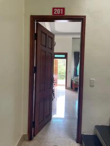 une porte menant dans un couloir avec un panneau sur celle-ci dans l'établissement Hoàng Bách homestay, à Dong Van