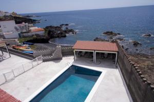 a villa with a swimming pool and a view of the ocean at Las Eras Nest Hostel in Las Eras