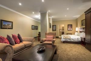 - un salon avec un canapé et un lit dans l'établissement ANEW Hotel Highveld Emalahleni, à Witbank