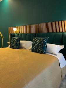 ein grünes Schlafzimmer mit einem großen Bett mit Kissen in der Unterkunft Loft Sirmione in Sirmione
