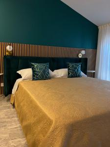 ein Schlafzimmer mit einem großen Bett und einer grünen Wand in der Unterkunft Loft Sirmione in Sirmione
