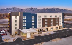 eine Ausstellung eines Hotelgebäudes mit einem Parkplatz in der Unterkunft SpringHill Suites By Marriott Salt Lake City West Valley in West Valley City