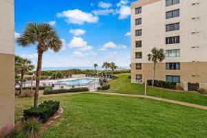 a view of a building and a yard with a pool at Unobstructed Oceanfront Views in Gated Community-2 Pools-Surf & Racquet B123 in Fernandina Beach