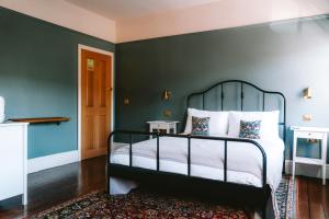 a bedroom with a bed with a green wall at Riversdale House Bed & Breakfast in Llangollen