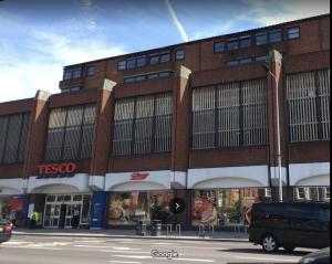 a tall brick building with a van parked in front of it at City Apartments near Seven Sisters in London