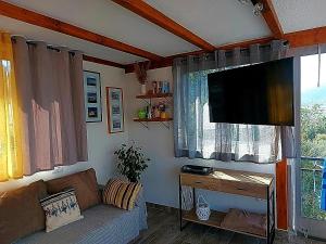 a living room with a couch and a flat screen tv at Apartmani Balan s vanjskim bazenom in Trogir