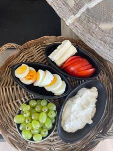 a table with three plates of cheese and fruit at Oikos Sani Suites in Sani Beach
