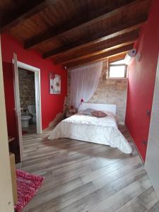 een slaapkamer met een bed en een rode muur bij The Queen in Giannetti