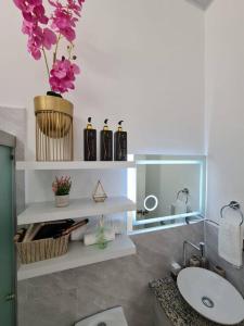 a bathroom with a sink and a vase with purple flowers at Casa familiar in San Miguel