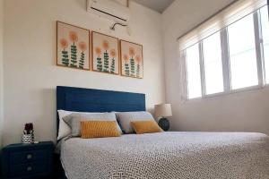 sypialnia z niebieskim łóżkiem i 2 żółtymi poduszkami w obiekcie Casa familiar w mieście San Miguel