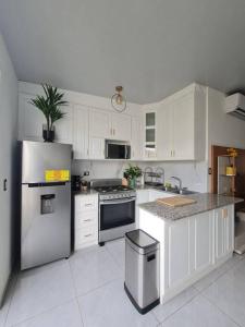 a kitchen with white cabinets and a stainless steel refrigerator at Casa familiar in San Miguel