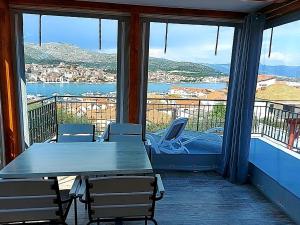 una mesa y sillas en un balcón con vistas en Apartmani Balan s vanjskim bazenom, en Trogir