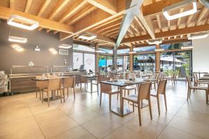 a restaurant with wooden ceilings and tables and chairs at VVF Les 7 Laux Massif de Belledonne in Prapoutel