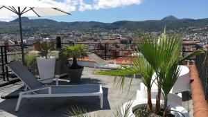 uma varanda com cadeiras e um guarda-sol e plantas em 5&5 Rooftop em Clermont-Ferrand