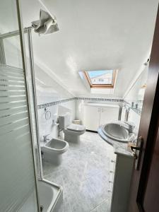 łazienka z 2 toaletami, umywalką i prysznicem w obiekcie Ferraguda Garden House w mieście Carregado