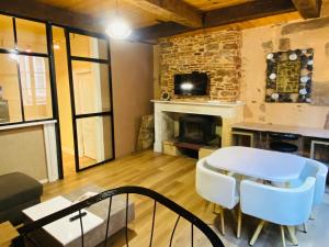 Una sala de estar con una mesa y una chimenea. en GITE URBAIN - Côté charme, en Rodez