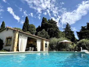 a villa with a swimming pool in front of a house at Appartement dans Mas Provencal in Grans