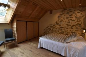 a bedroom with a stone wall and a bed at VAUJANYLOCATIONS - Sertetsagne in Vaujany +6 photos