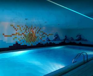 a large swimming pool with blue lighting in a room at Penzión Stefanie in Vinné