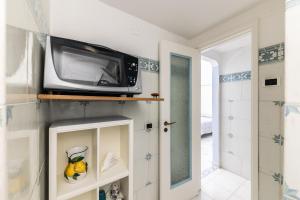 Un microondas colocado encima de un estante en una habitación. en Casa Sabina - Anacapri, en Anacapri