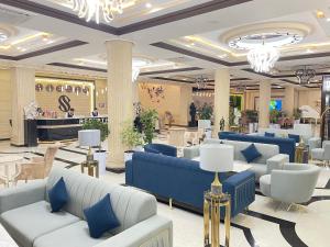 een lobby met blauwe en witte banken in een winkelcentrum bij Simma Hotel Spa & Waterpark in Tasjkent