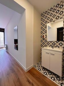 a kitchen with white walls and wood floors at Hostal Arenal Madrid in Madrid