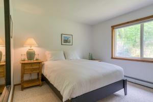 a bedroom with a white bed and a window at The Mountain House Windham Retreat with Hot Tub! in Windham