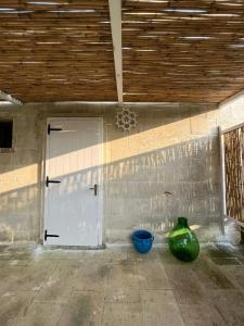un garage con una porta e due vasi sul pavimento di Masseria Tumara Rooms and Apartments a Otranto