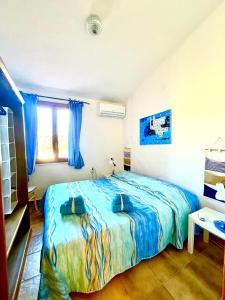 een slaapkamer met een groot bed met blauwe lakens bij Villa bifamiliare "Terrazza sul Golfo " in Sorso