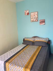 a bed in a bedroom with two pictures on the wall at Central Appart in Mamoudzou