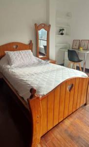 a bed with a wooden frame in a room at Bonita casa en sector residencial al norte de Loja in Loja