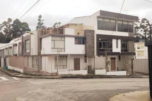 ロハにあるBonita casa en sector residencial al norte de Lojaの通りに柵のある白い家