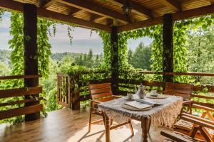 einen Tisch und Stühle auf einer Veranda mit Reben in der Unterkunft Dom pod Wiankami in Korczyna