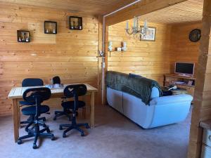 a room with a table and chairs and a couch at Chalet chaleureux in Billy