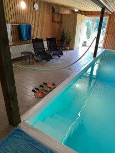 a swimming pool with two chairs and a table at Home of Oasis in Surwold