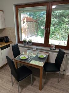 mesa de comedor con sillas y ventana en Home of Oasis, en Surwold