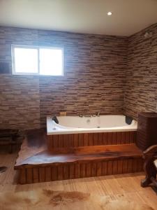 Cette chambre dispose d'une baignoire et d'un mur en briques. dans l'établissement Hermosa cabaña en Lago Ranco, à Lago Ranco