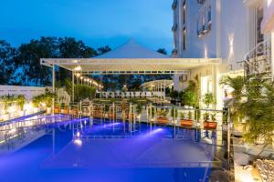 uitzicht op een zwembad van het hotel 's nachts bij Hotel Caesars Palace in Bhopal