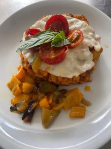 a white plate with a sandwich with cheese and vegetables at Punto Verde in Noci