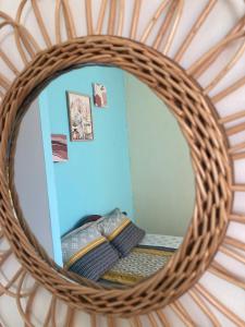 a mirror in a wicker room with a bed at Central Appart in Mamoudzou