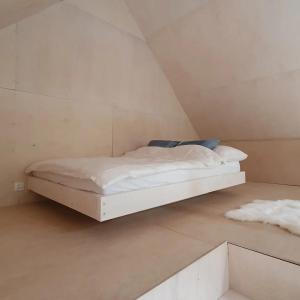 a small white bed in a room with at Schody do wody Domek z linią brzegową Kaszuby sauna goraca balia 