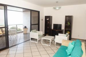a living room with a couch and chairs and a tv at Lindo e bem localizado 3 quartos de frente p/ Mar - Praia do Forte - CF06 in Cabo Frio