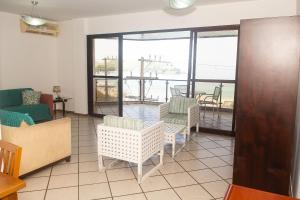 sala de estar con sillas y ventana grande en Lindo e bem localizado 3 quartos de frente p/ Mar - Praia do Forte - CF06, en Cabo Frío