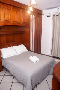 a bedroom with a bed with two towels on it at Lindo e bem localizado 3 quartos de frente p/ Mar - Praia do Forte - CF06 in Cabo Frio