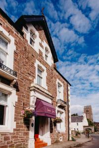 a brick building with a purple awning on it at Coorie Inn Restaurant and Rooms in Crieff