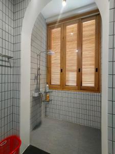 La salle de bains est pourvue d'une douche et d'une fenêtre. dans l'établissement Village Mai, à Ấp Bình Hưng