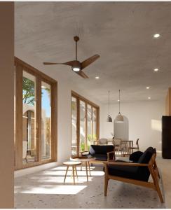 - un salon avec un ventilateur de plafond et une table dans l'établissement Village Mai, à Ấp Bình Hưng