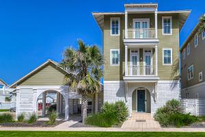 a house with a palm tree in front of it at Sunset Cove at Palmilla Beach in Port Aransas